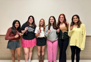 Girls For The Future officers holding up the ribbons they made for breast cancer awareness. The club made over 300 ribbons to pass out during the month of October.