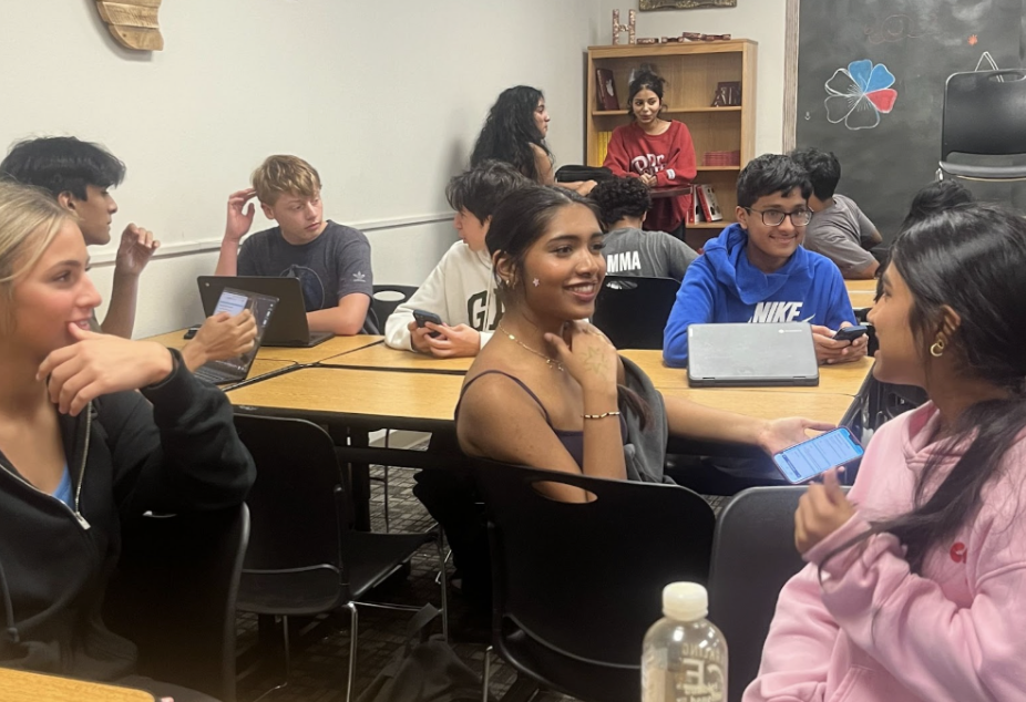 Debate students discuss at a club meeting. The debate program has helped numerous students develop their confidence and public speaking skills.